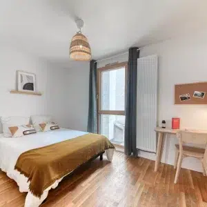 Grande chambre lumineuse avec un lit double en coliving à Lyon
