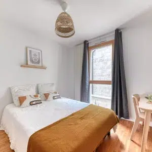 Chambre lumineuse avec un lit double en coliving à Lyon